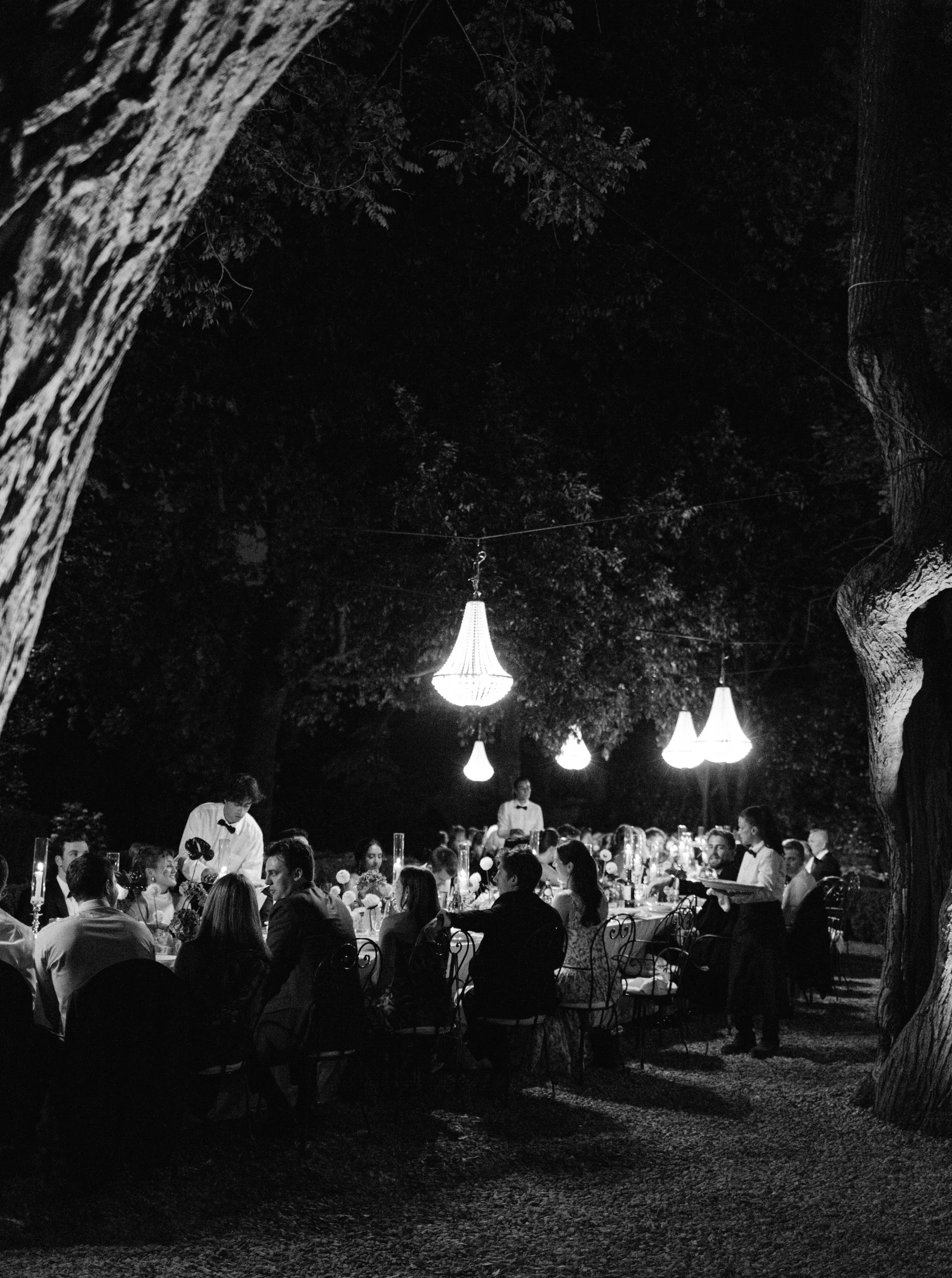Crystal chandeliers above the dinner at night in black and white, Borgo Stomennano, Tuscany