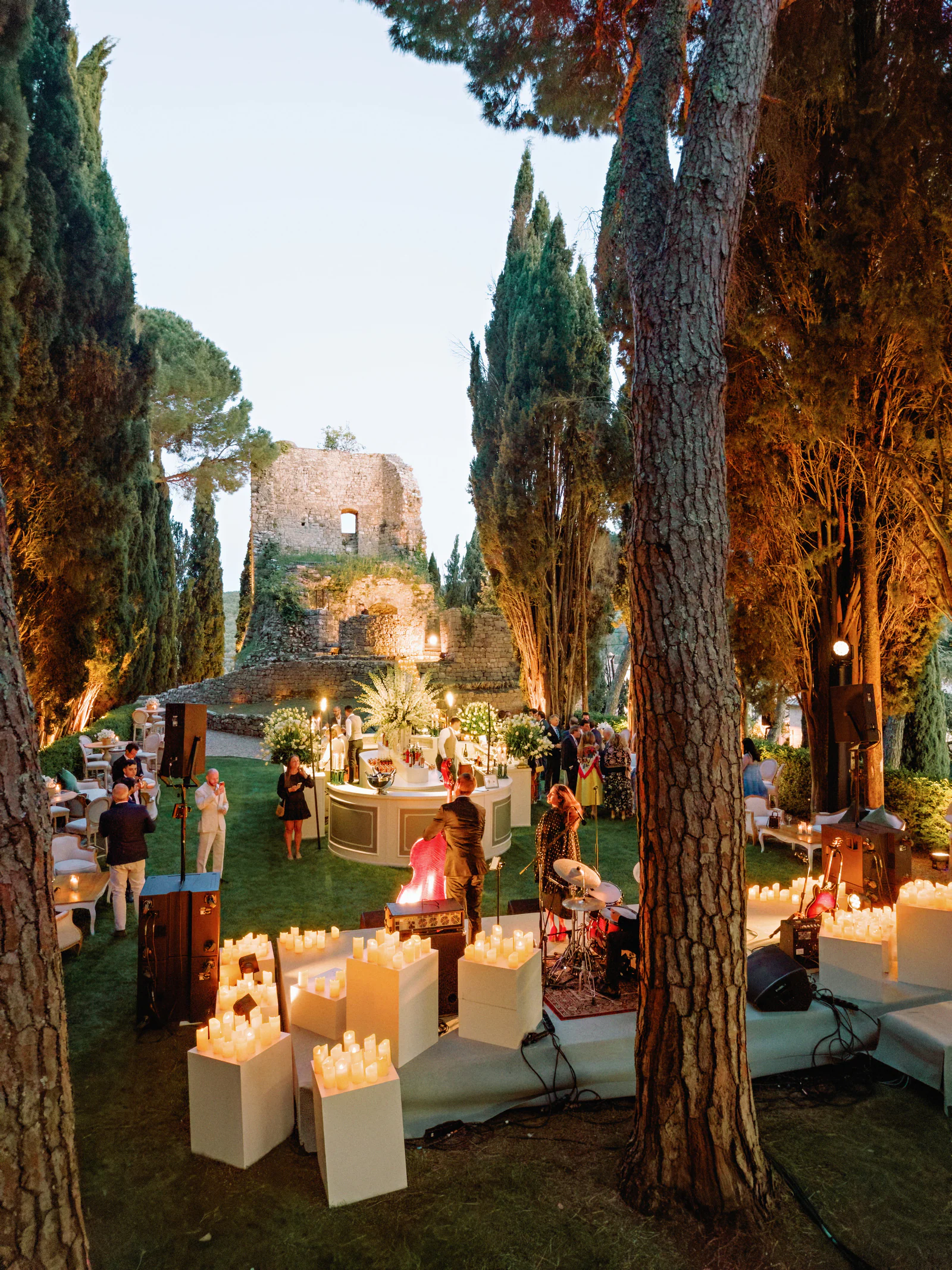 Cypress grove lit with candles and low seating for the rehearsal dinner, Castiglion del Bosco, A Rosewood Hotel, Tuscany