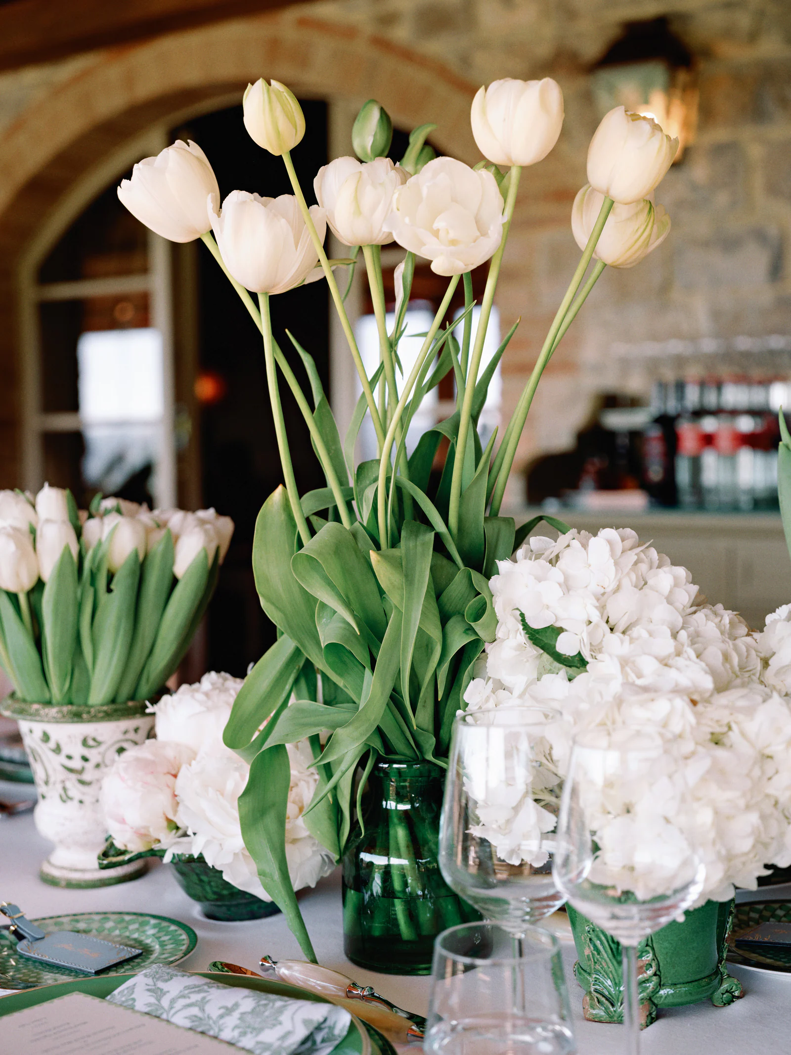 White tulips and hydrangeas in cut-glass vases on the rehearsal-dinner table, Castiglion del Bosco, A Rosewood Hotel