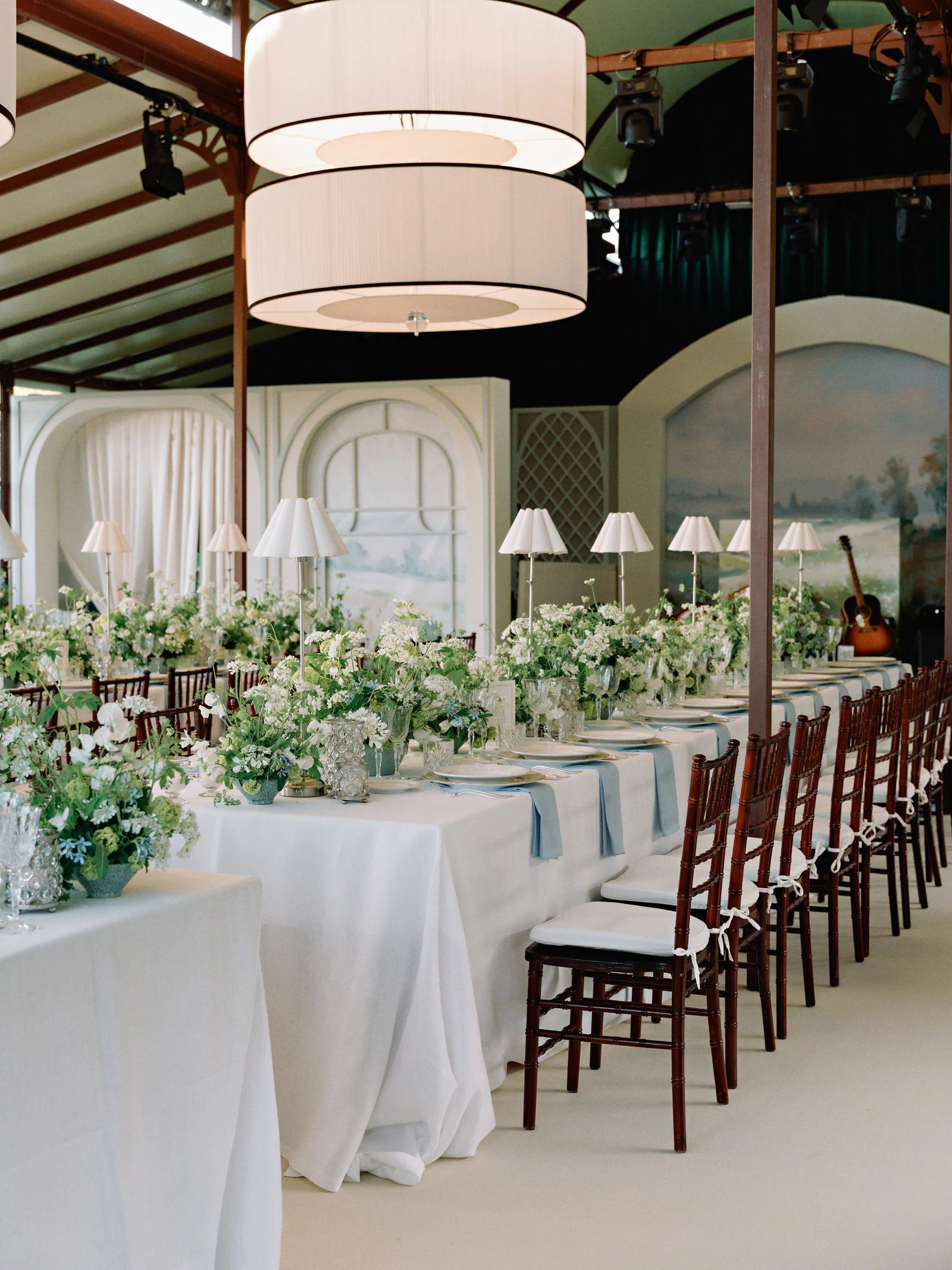 Long ivory-linen tables and white florals in the glazed pavilion at Castiglion del Bosco, A Rosewood Hotel, Tuscany