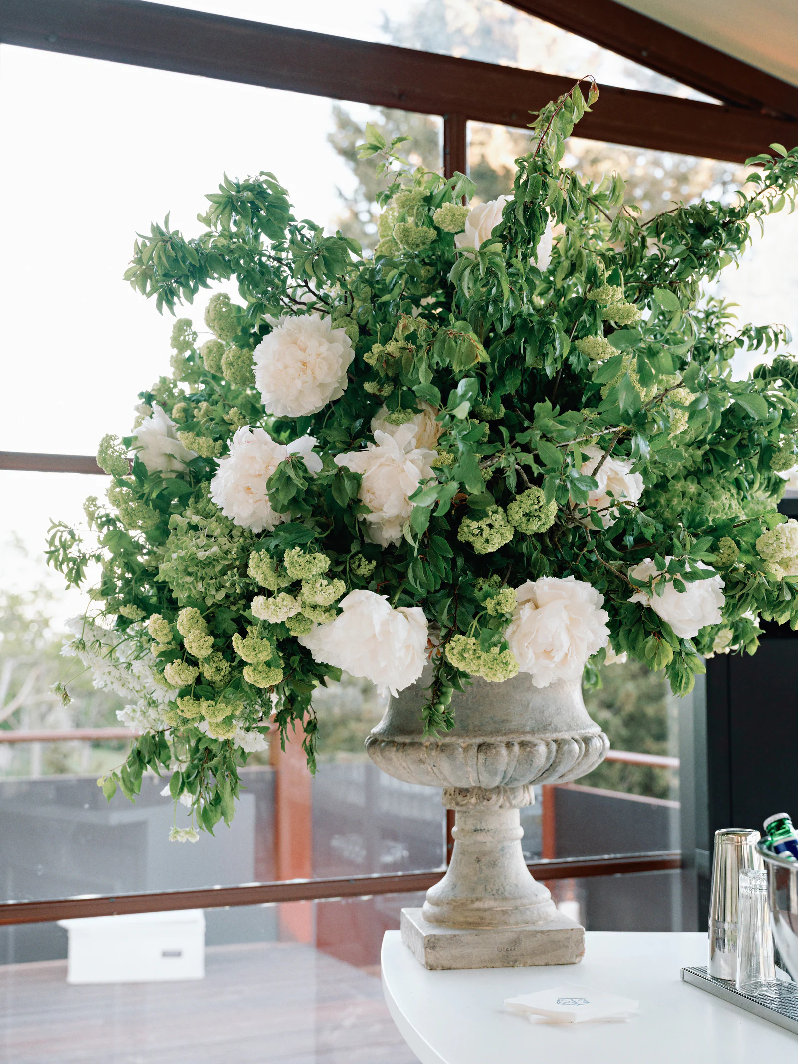 Tall white and green floral urn on a stone pedestal in the dinner pavilion, Castiglion del Bosco, A Rosewood Hotel