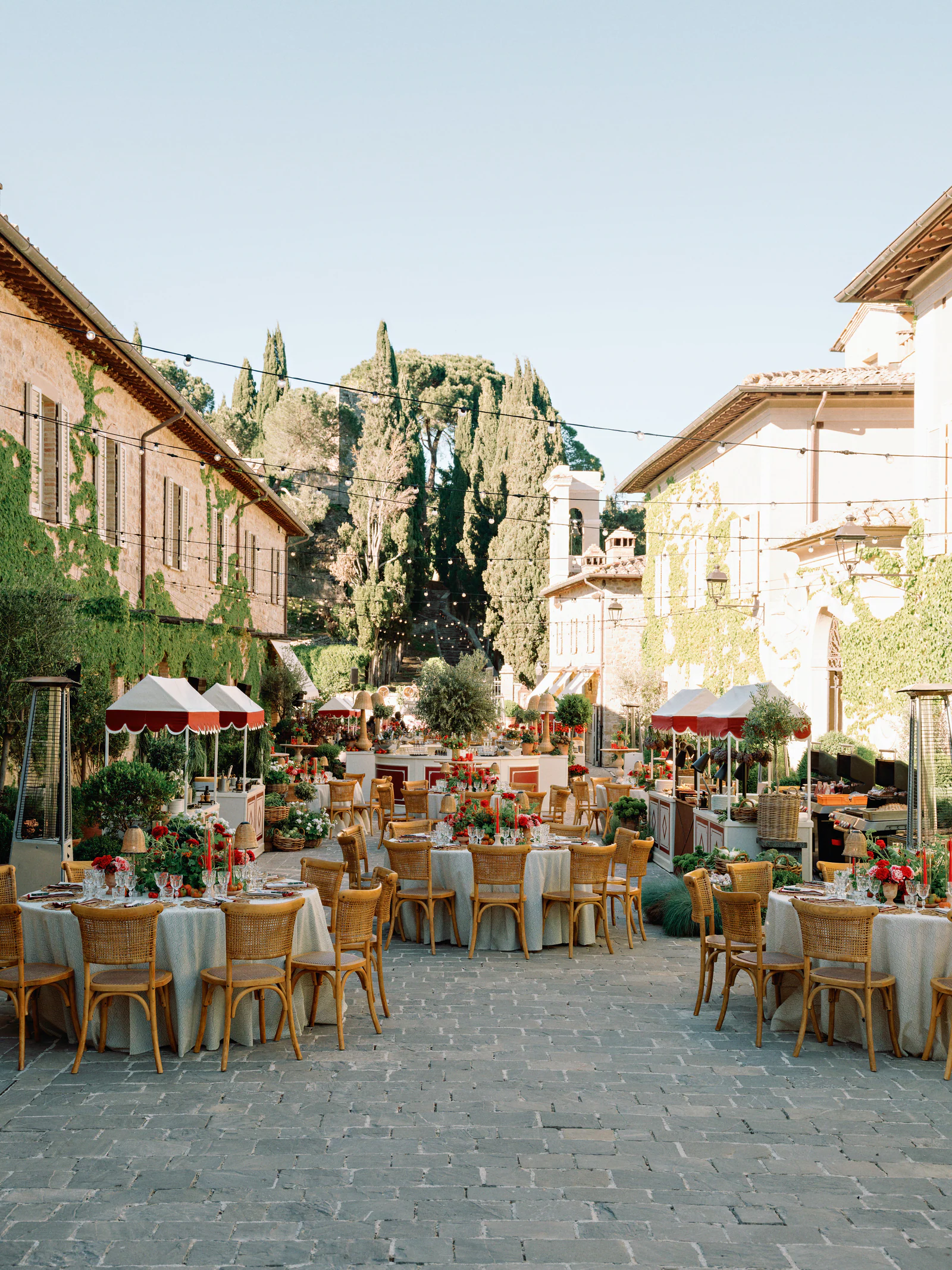 Borgo lane of Castiglion del Bosco, A Rosewood Hotel, laid with tables and red awnings for the welcome dinner, Val d'Orcia