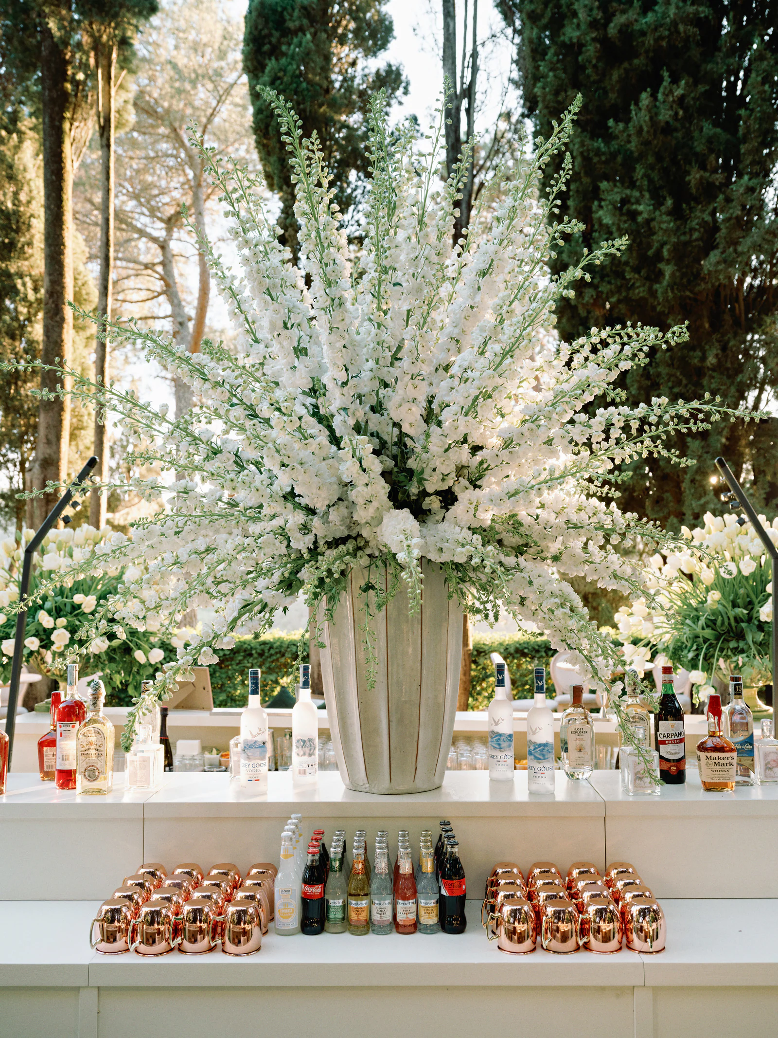 White delphiniums above the open-air bar at the welcome party of Sophie and Gordon's wedding, Castiglion del Bosco, A Rosewood Hotel, Tuscany