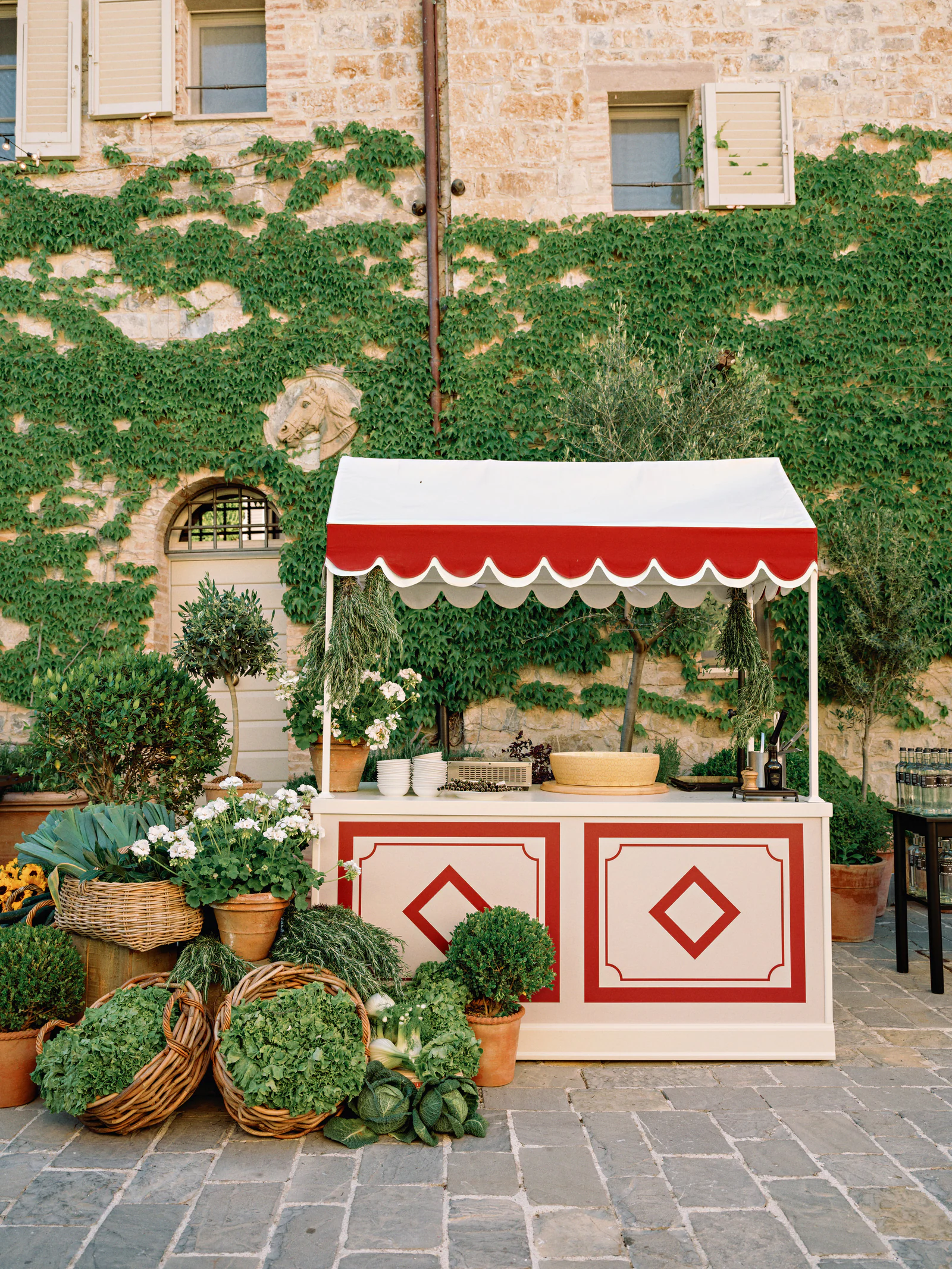 Red and white striped market stall of Tuscan produce at the welcome party, Castiglion del Bosco, A Rosewood Hotel
