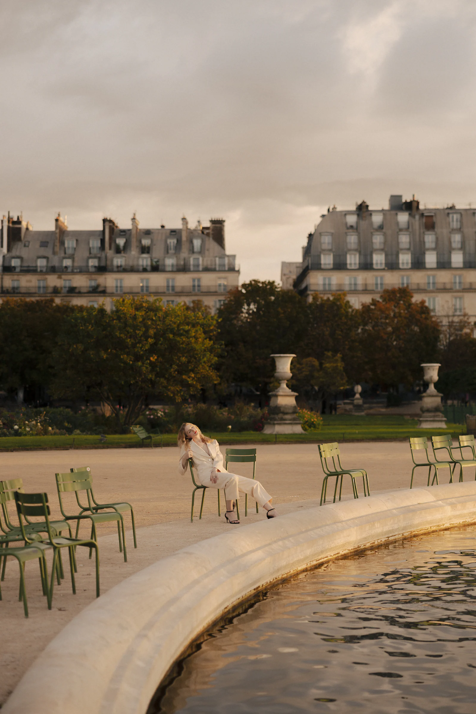 The bride on a green chair by the Tuileries basin at dusk, Paris