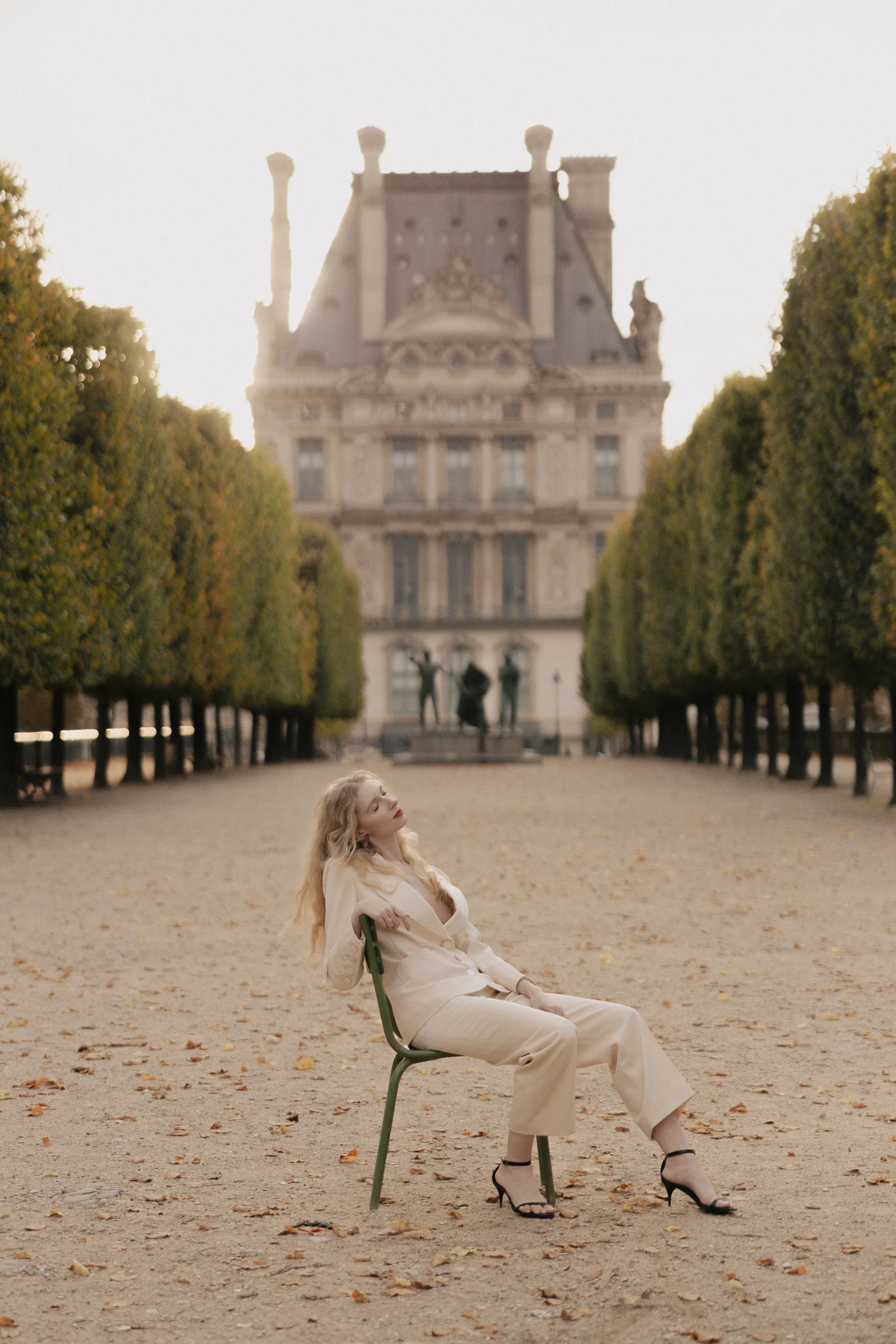 Bride seated on a Tuileries chair facing the Pavillon de Flore of the Louvre, Paris