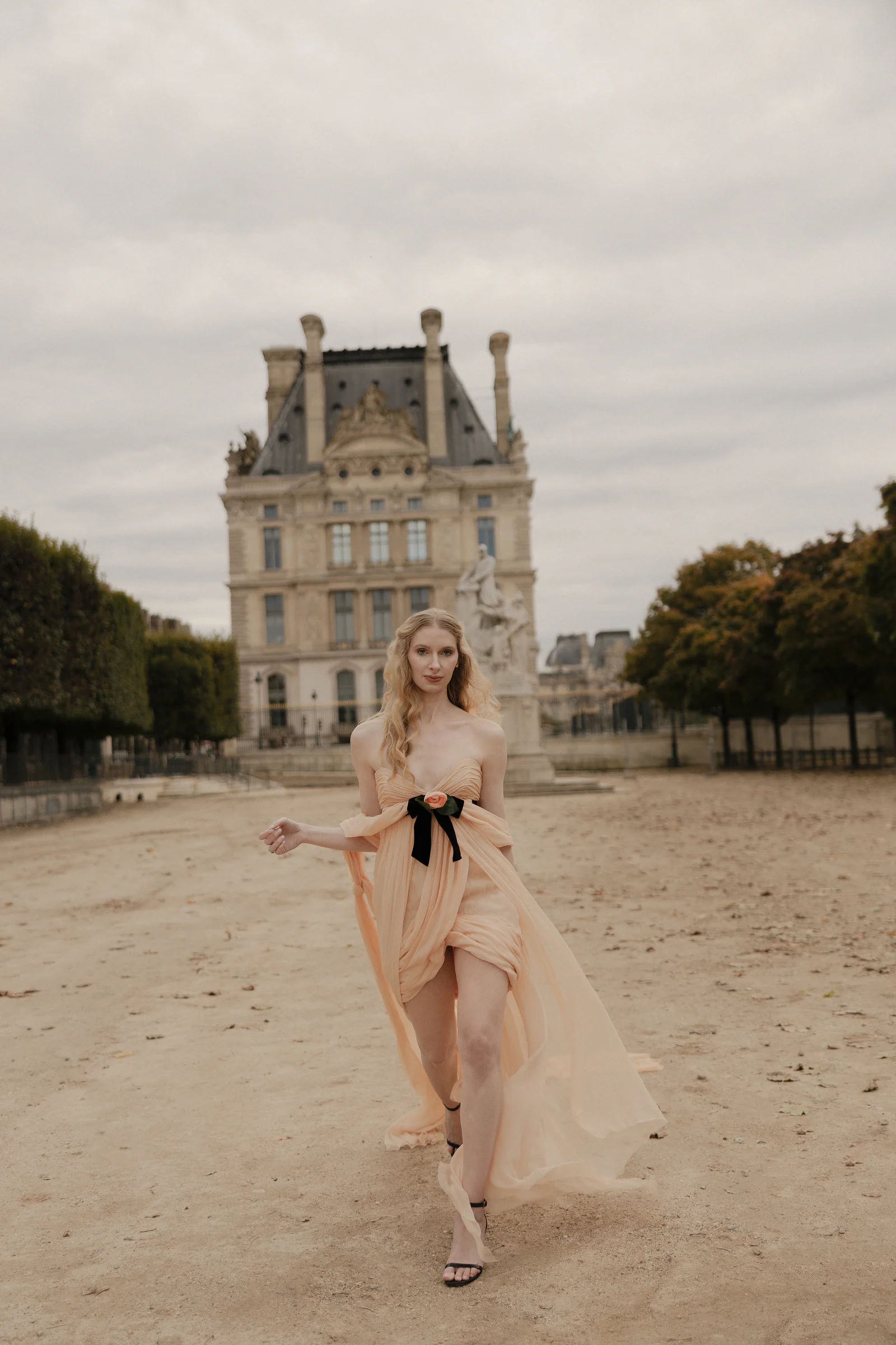 Bride walking the Tuileries garden in vintage Chanel, the Louvre behind, Paris
