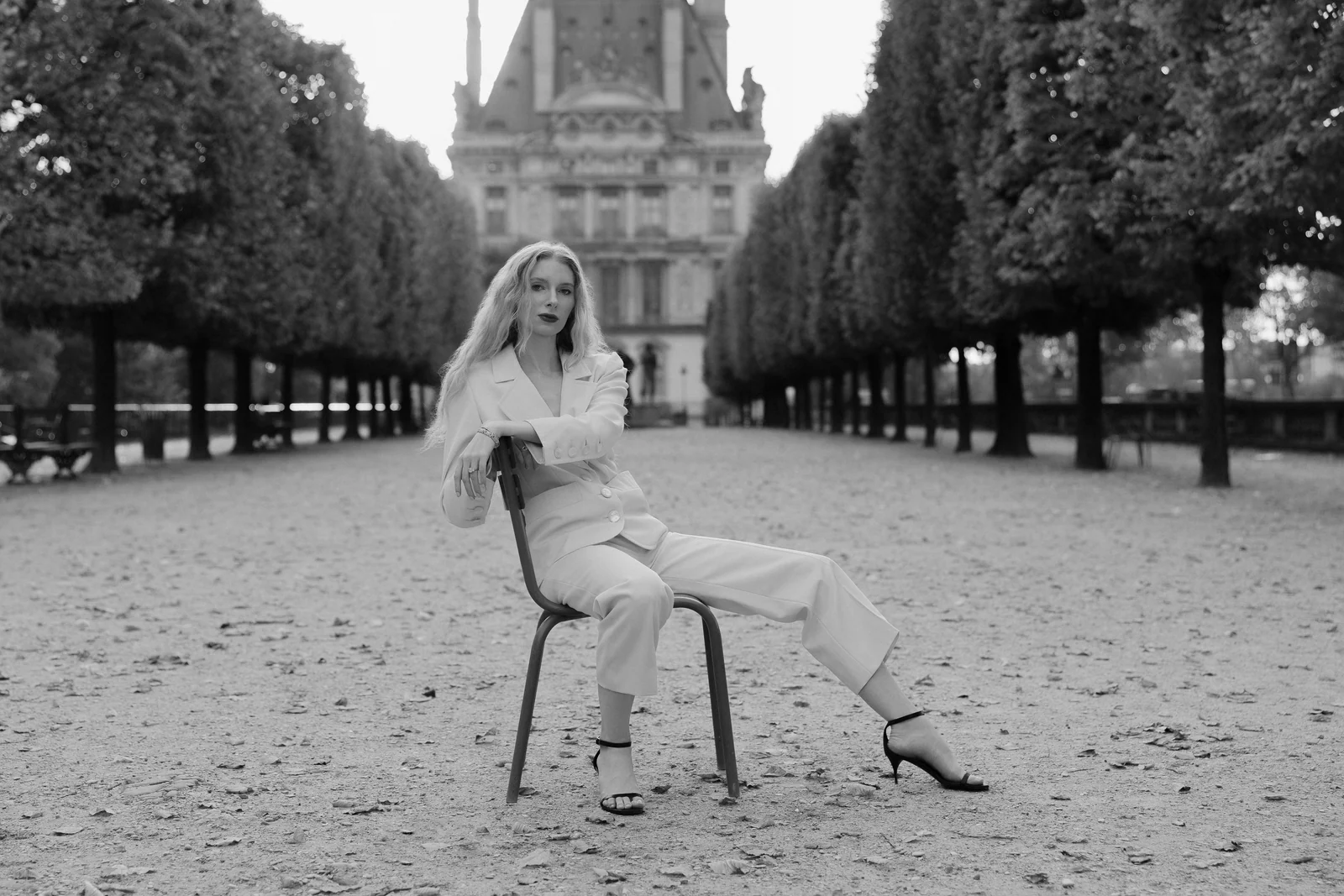 Bride seated on a Tuileries chair along the allée, black and white, Paris