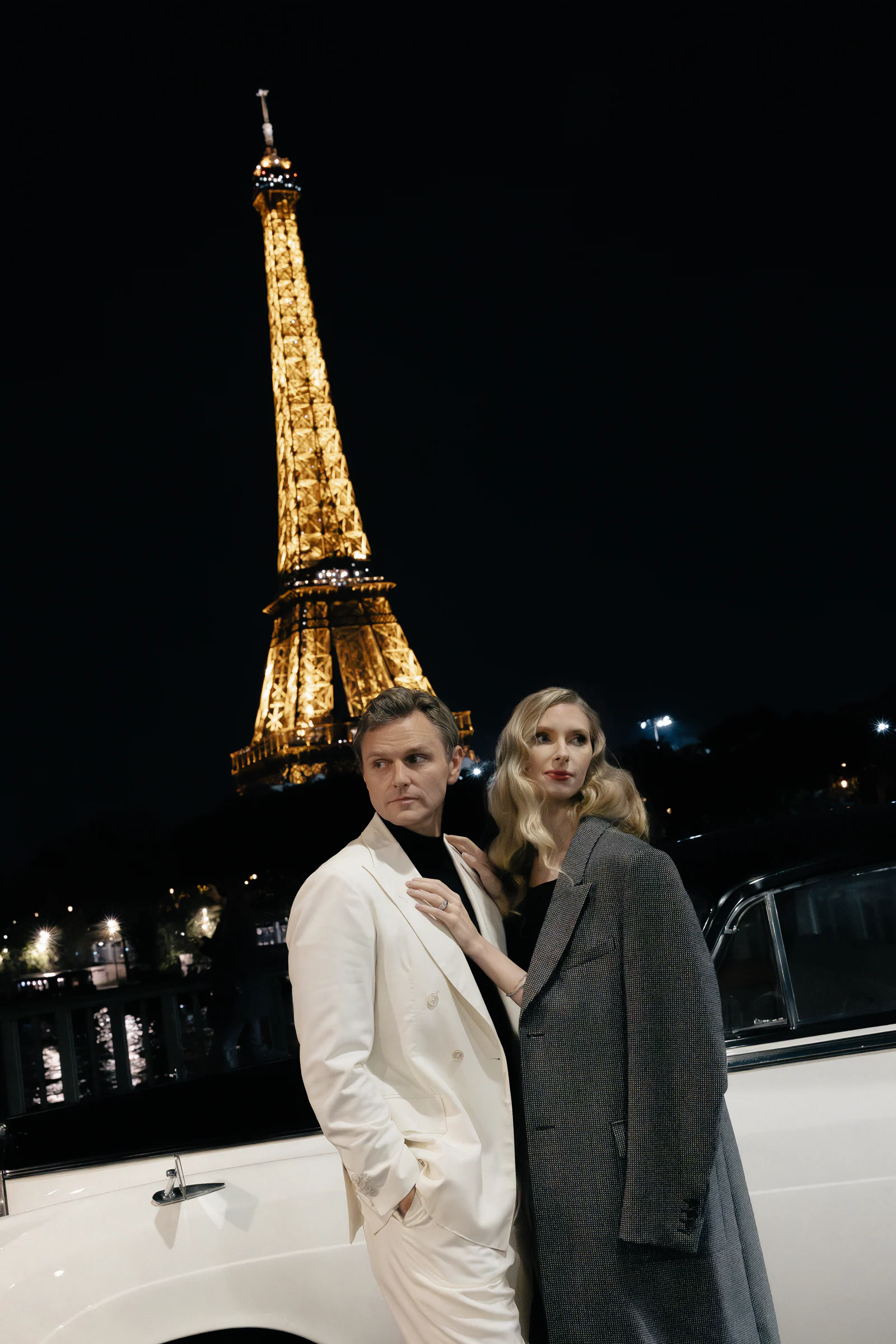 Couple before the illuminated Eiffel Tower at night, Paris