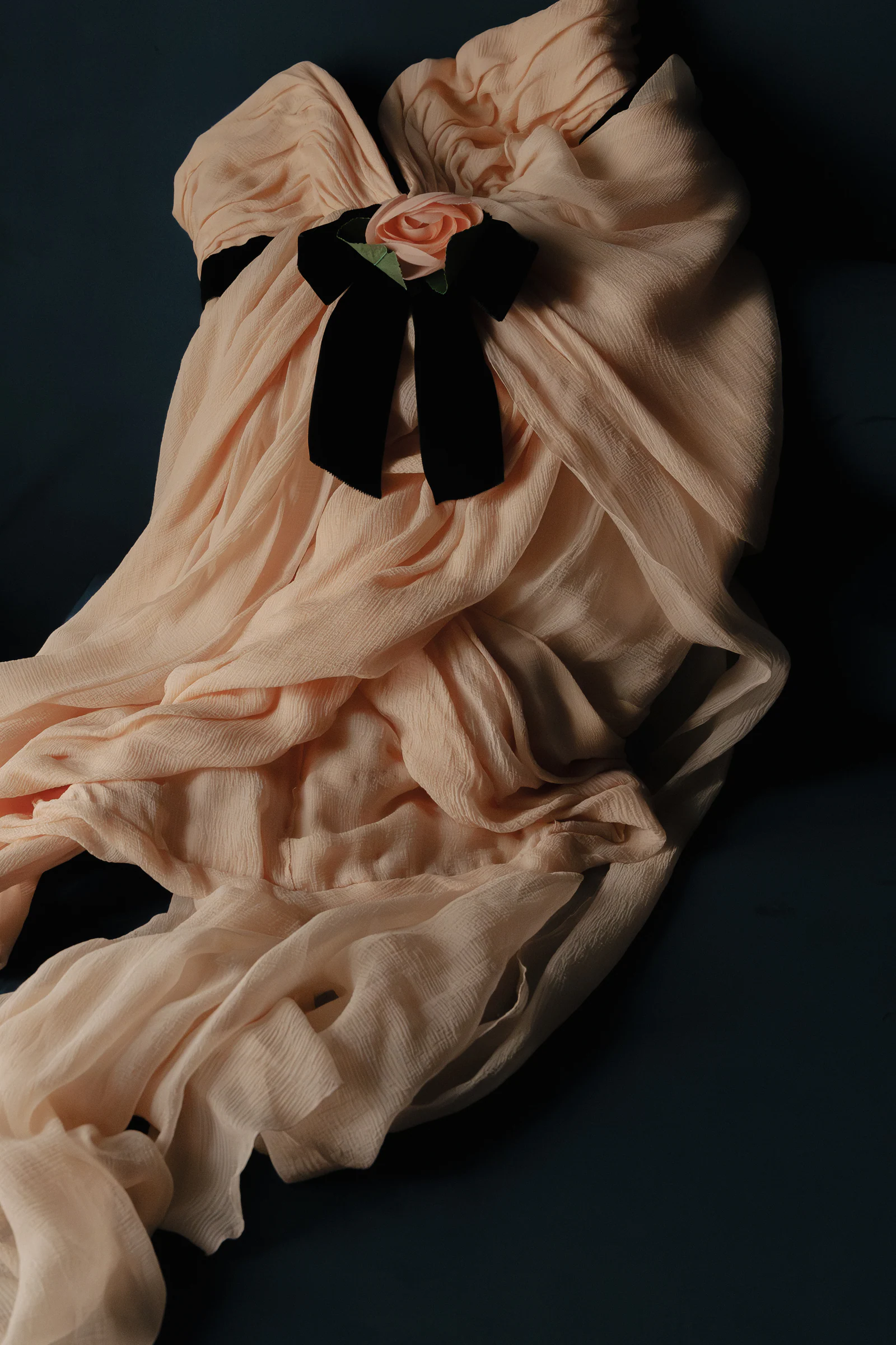 The pink vintage Chanel gown and its black velvet bow laid flat, Paris